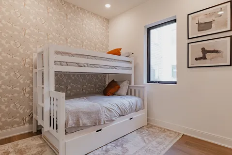 a bedroom with a bed and wooden floor