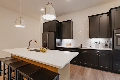 a kitchen with a sink a kitchen island and stainless steel appliances