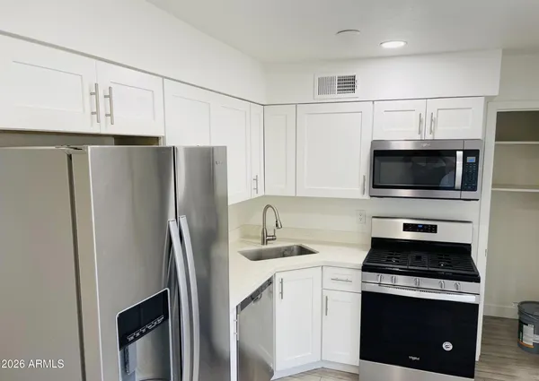 a kitchen with stainless steel appliances a refrigerator stove and microwave