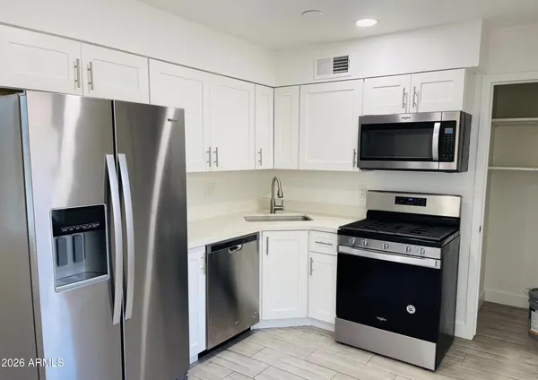 a kitchen with stainless steel appliances a refrigerator stove and microwave
