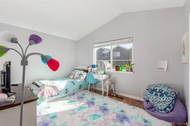 a bedroom with a bed and a wooden floor