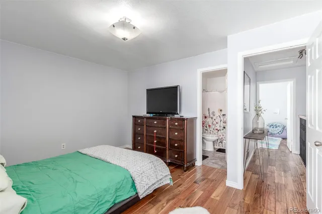 a bedroom with a bed and a flat tv screen on a dresser