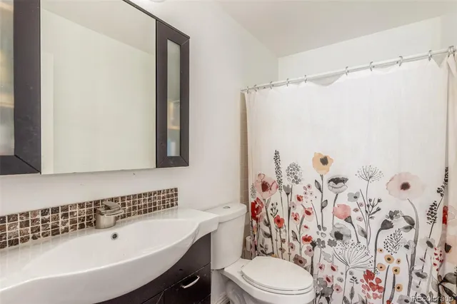 a bathroom with a sink a toilet and shower curtain