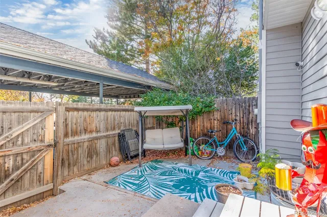 a view of a patio with table and chairs potted plants and wooden fence