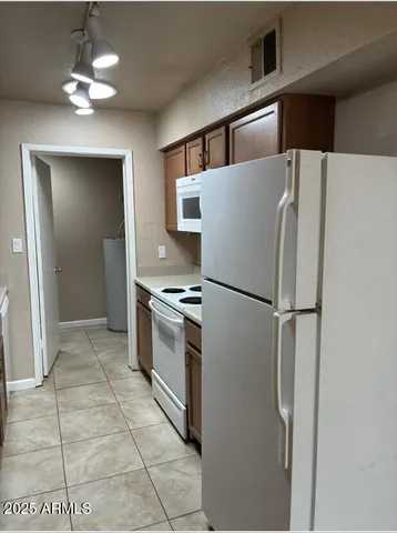 a kitchen with stainless steel appliances a refrigerator and a chandelier