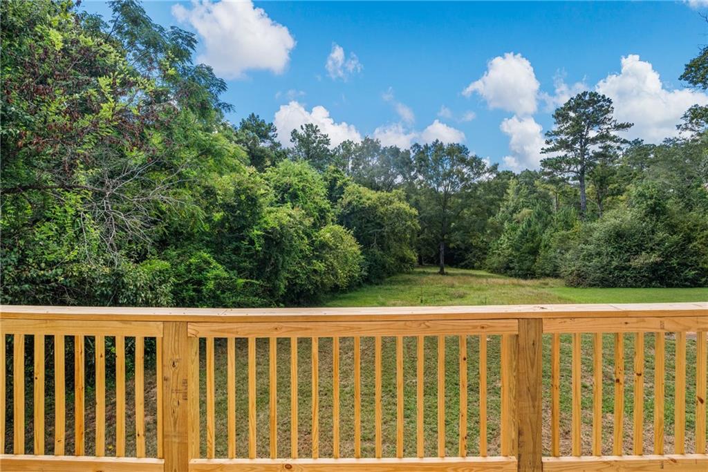 2107 South Seale Road Phenix City, AL 36869 - Photo 24 of 35 Wooden deck with natural wood railing overlooking a spacious grassy area with mature trees