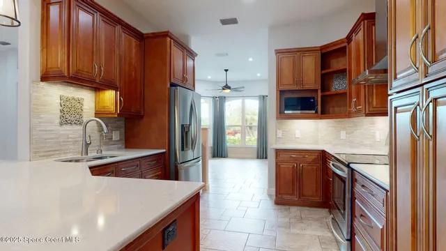 a kitchen with stainless steel appliances granite countertop a stove a sink and a microwave