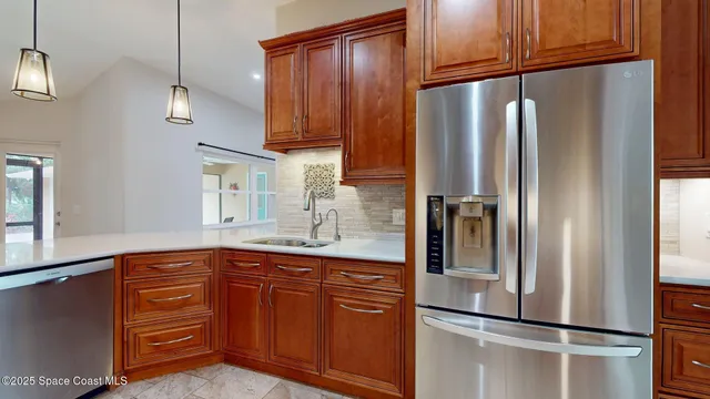 a kitchen with stainless steel appliances granite countertop a sink a refrigerator and a stove