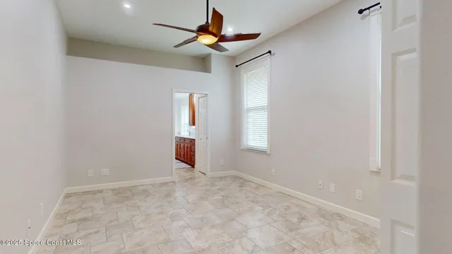 an empty room with a window and ceiling fan