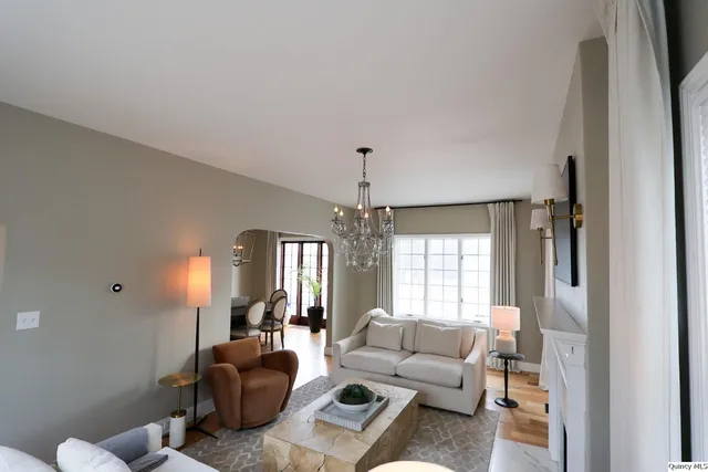 a living room with furniture and a chandelier