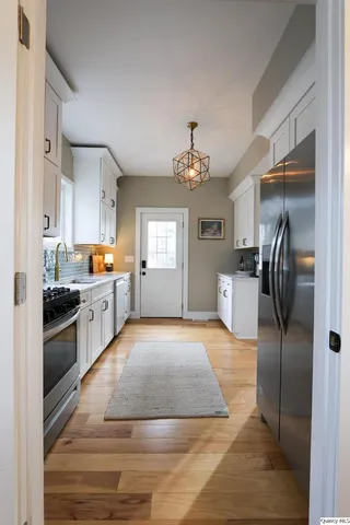 a large kitchen with stainless steel appliances kitchen island granite countertop a refrigerator and a stove top oven