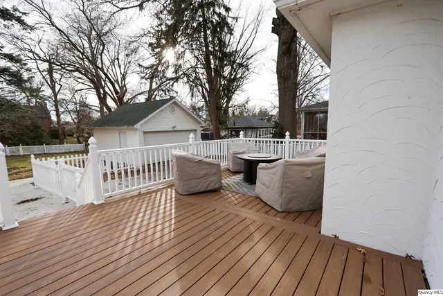 a view of a house with wooden deck and furniture
