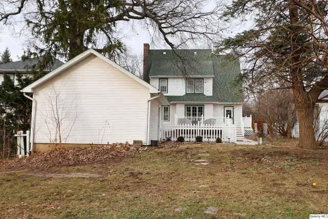 a view of a house with a large tree in front of it
