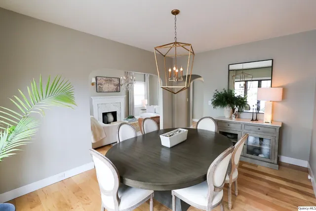 a view of a dining room with furniture a chandelier and wooden floor
