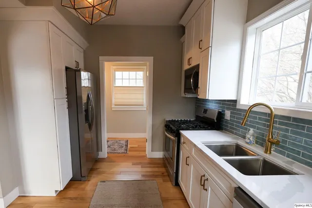 a kitchen that has a sink and a stove in it