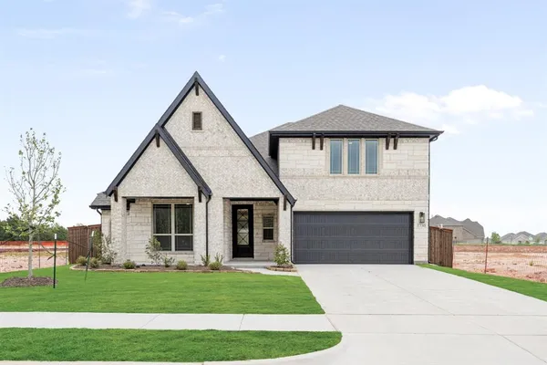 a front view of a house with a garden and yard