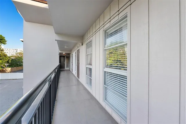 a view of a hallway with wooden floor and stairs