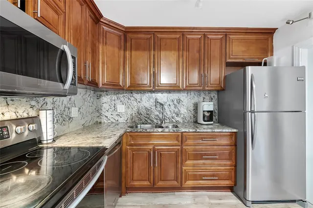 a kitchen with granite countertop a refrigerator stove and microwave