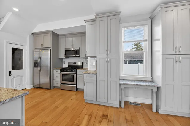 a kitchen with stainless steel appliances granite countertop a refrigerator and a stove top oven