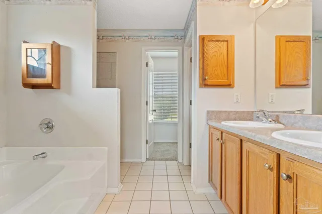 a bathroom with a granite countertop sink a mirror a bathtub and shower