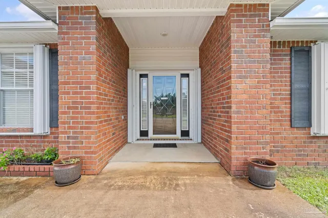 a view of a brick house with potted plants