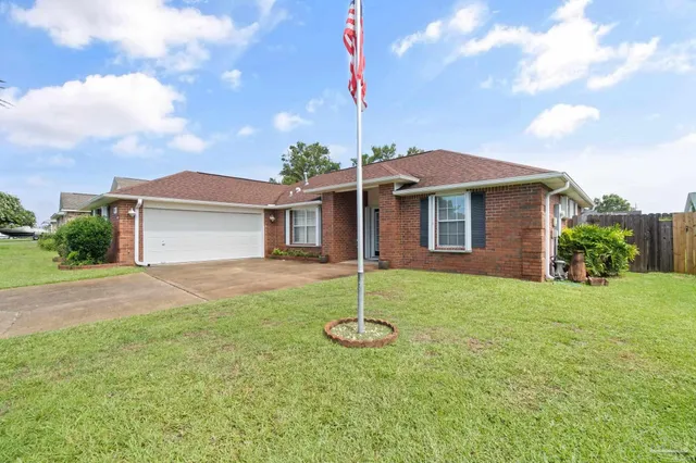 a view of a house with a backyard and a tree