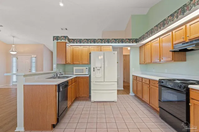 a kitchen with a stove a sink and a refrigerator
