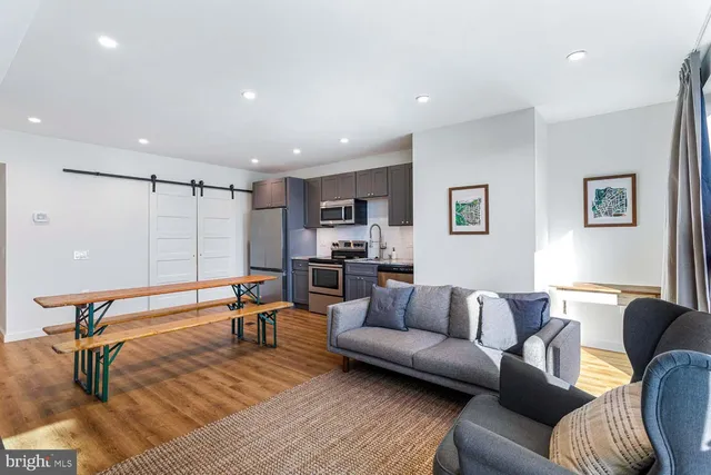 a living room with furniture a flat screen tv and a table