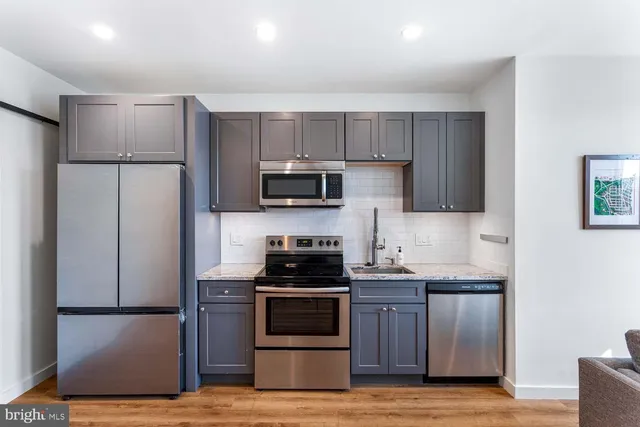 a kitchen with granite countertop cabinets stainless steel appliances and a sink