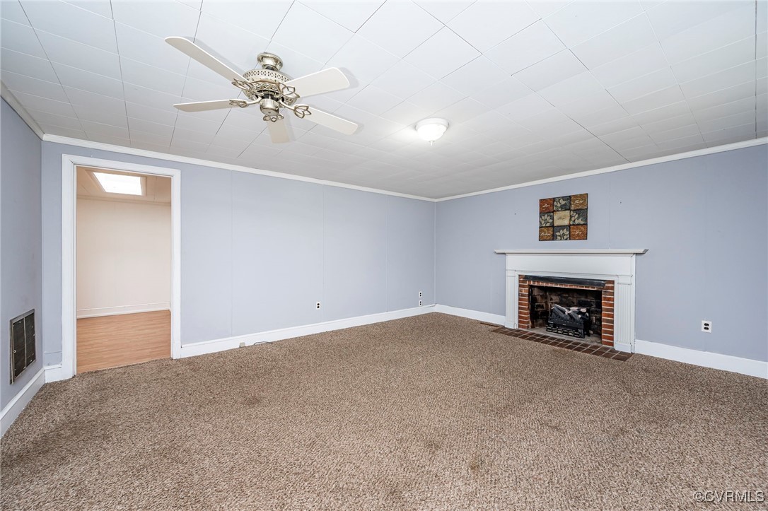 Unfurnished living room with carpet, ceiling fan,