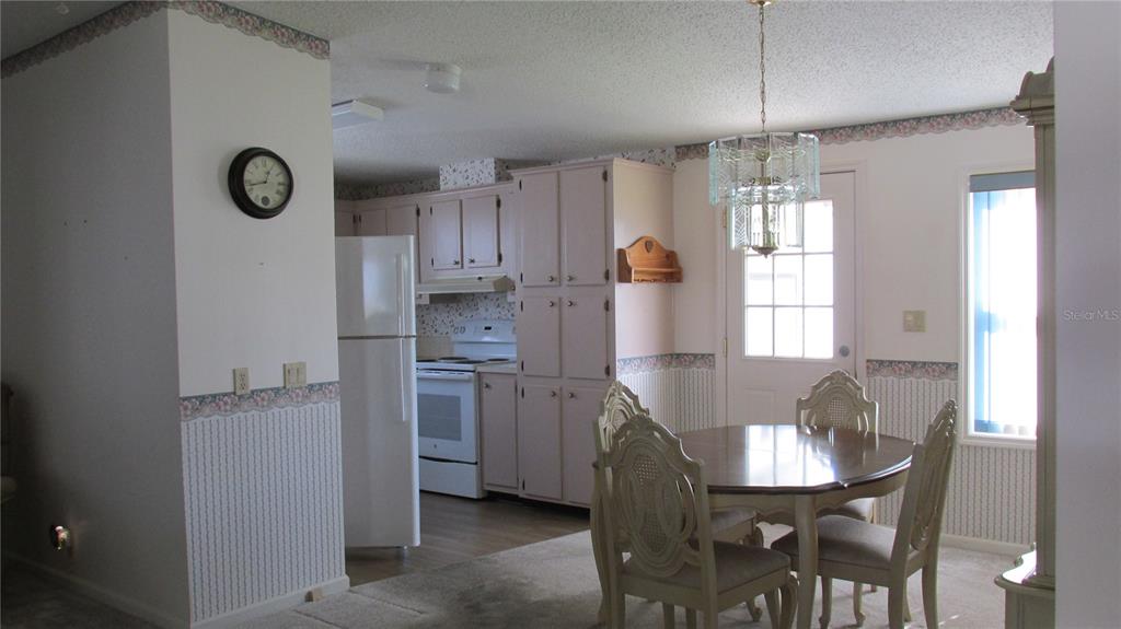 253 Ramsgate Way Haines City, FL 33844 - Photo 6 of 21 a kitchen with stainless steel appliances granite countertop a dining table chairs and white cabinets