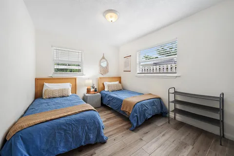 a bedroom with two beds and painting on the wall