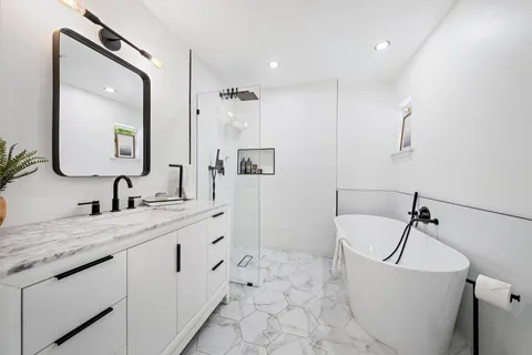 a bathroom with a granite countertop sink mirror and bathtub