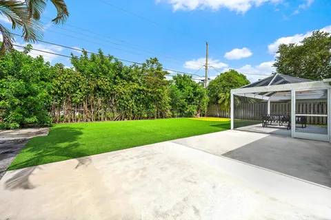 a view of a house with a yard and potted plants