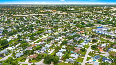 an aerial view of residential houses with outdoor space and trees