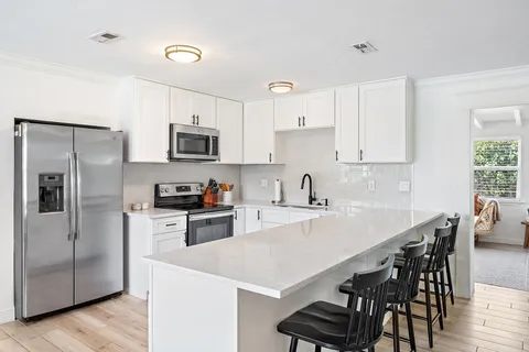 a kitchen with kitchen island a refrigerator stove and microwave