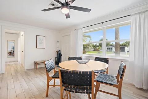 a dining room with furniture a window and wooden floor