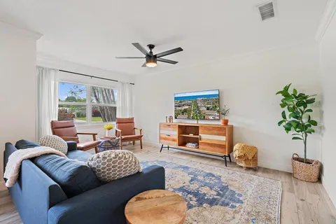 a living room with furniture a window and a potted plant