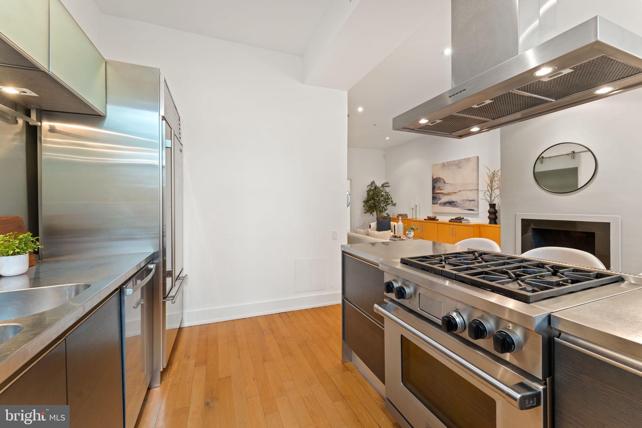 1516 R Street Northwest, Unit 3 Washington, DC 20009 - Photo 12 of 28 a kitchen with granite countertop stainless steel appliances a stove a sink and a refrigerator