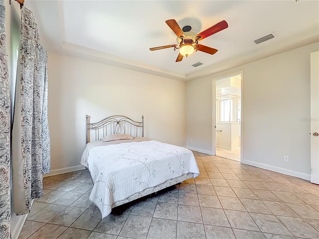 5510 Celebration Way Leesburg, FL 34748 - Photo 21 of 62 a bedroom with a bed and a ceiling fan