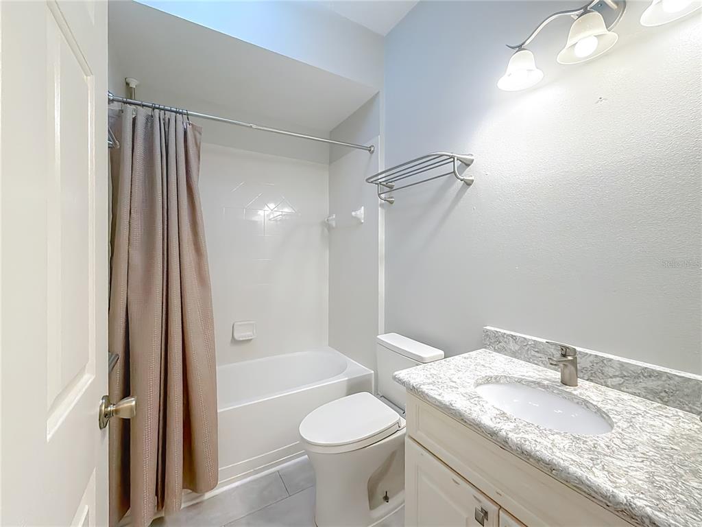 5510 Celebration Way Leesburg, FL 34748 - Photo 31 of 62 a bathroom with a granite countertop sink toilet and shower