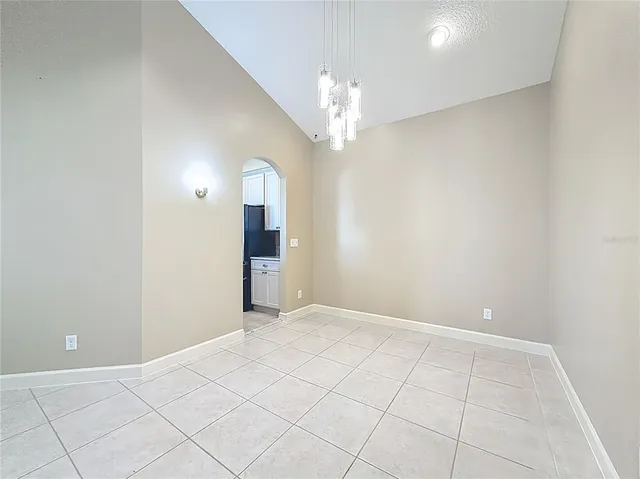 a view of an empty room with a chandelier fan