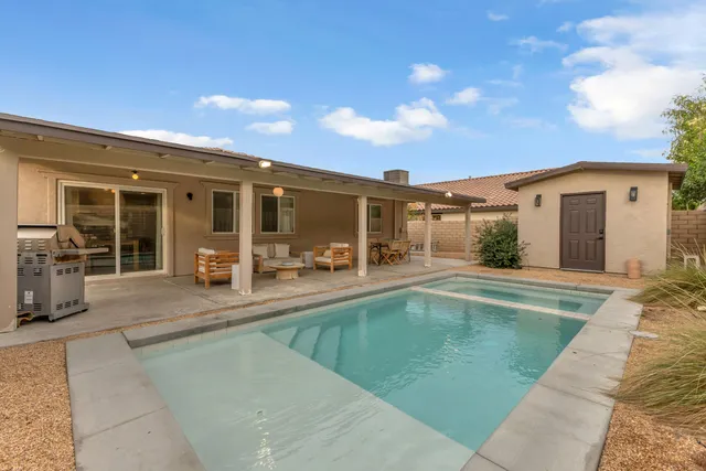 a view of a house with backyard barbeque and sitting area
