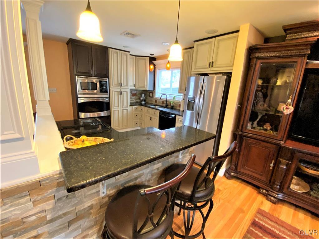 314 Willow Road Hellertown, PA 18055 - Photo 6 of 31 a kitchen with stainless steel appliances granite countertop a refrigerator a stove top oven with a dining table and chairs