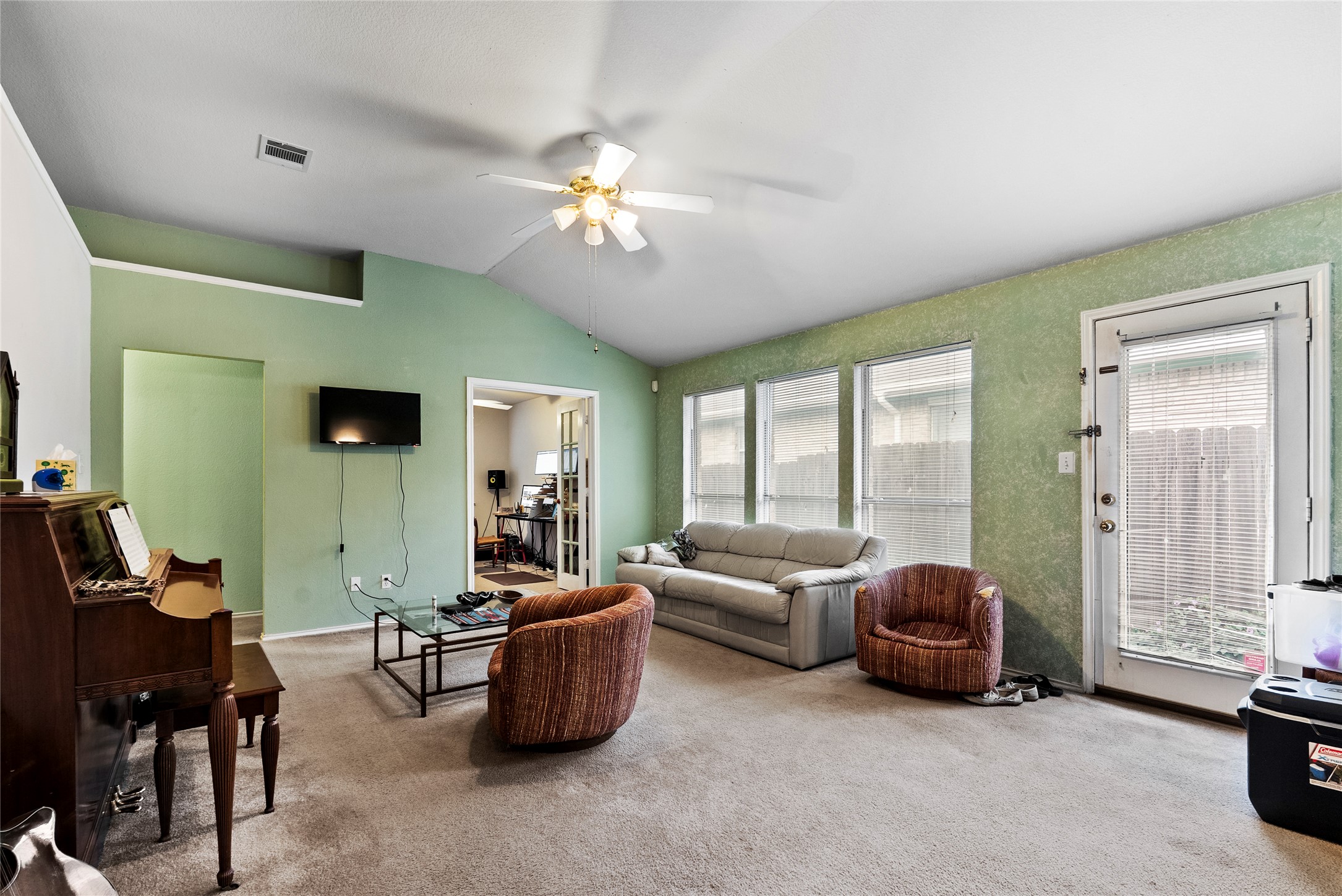 120 Shenandoah Trail Elgin, TX 78621 - Photo 5 of 16 Carpeted living area with vaulted ceiling and a ceiling fan