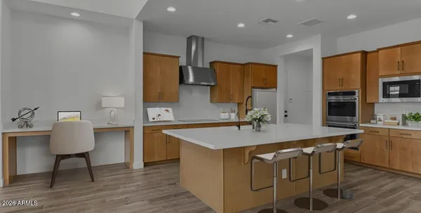 a kitchen with stainless steel appliances granite countertop a sink a stove a refrigerator cabinets and chairs