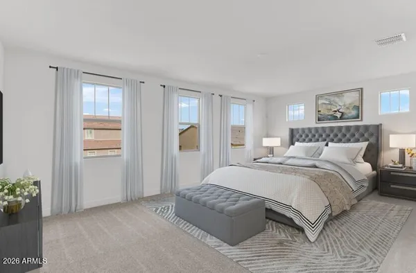 a bedroom with a large bed and a chandelier