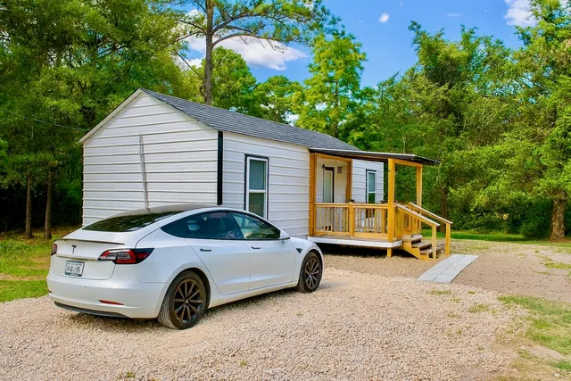 a view of a white car parked in front of a house
