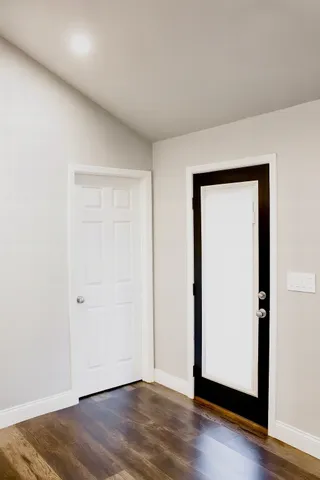 an empty room with wooden floor and closet