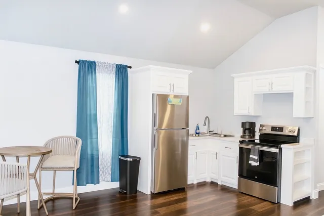 a kitchen with a refrigerator and a stove top oven